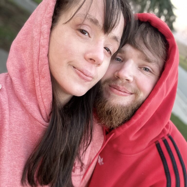 Nina and her husband leaning close together outdoors.