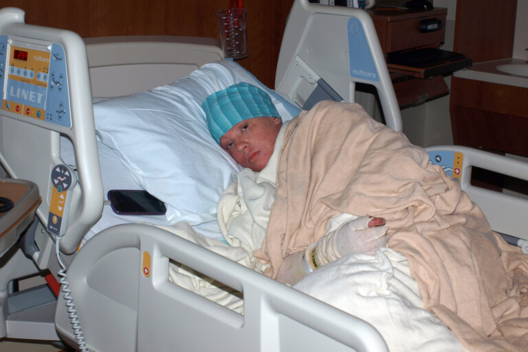 Nina resting in a hospital bed during a severe health crisis.